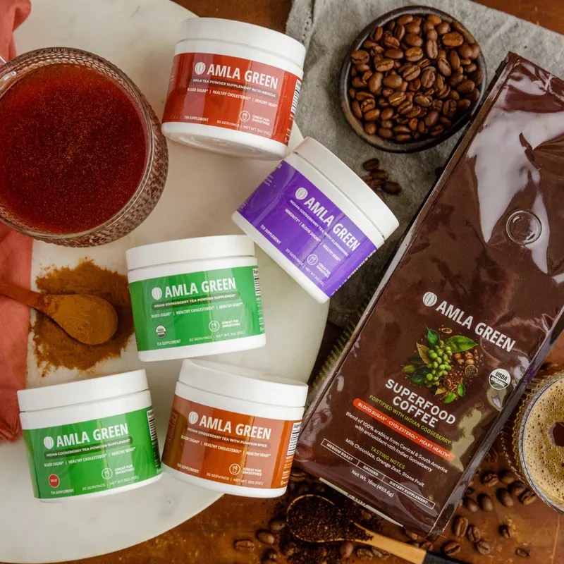 Flat lay of Amla Green supplement jars and Superfood Coffee surrounded by drinks and spices