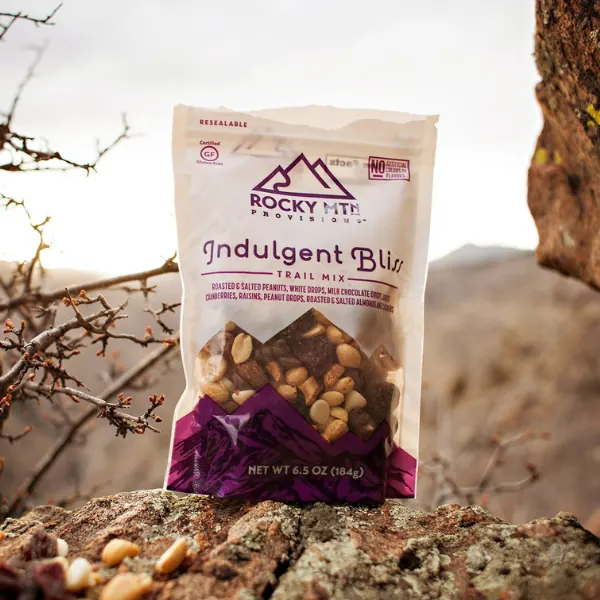 Bag of Rocky Mtn Indulgent Bliss trail mix on a sunlit rock