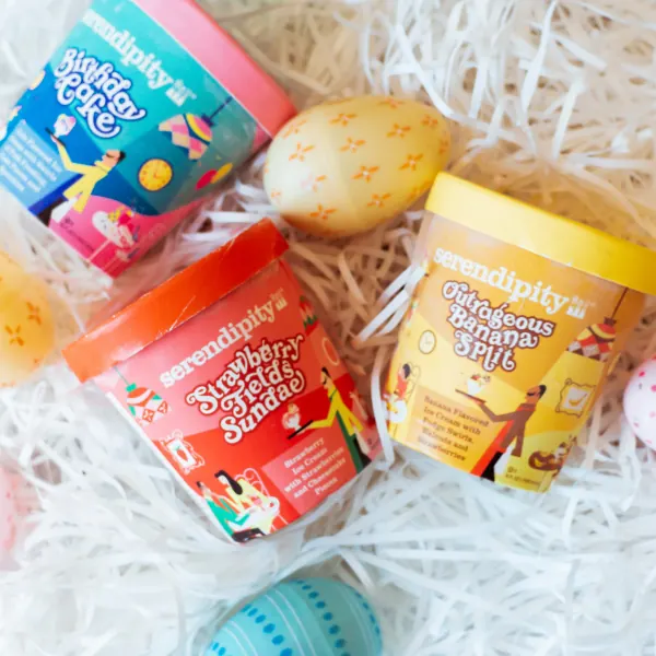 Serendipity ice cream pints nestled in Easter basket grass with decorated eggs