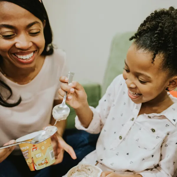 Mother and daughter smiling as they share Serendipity ice cream